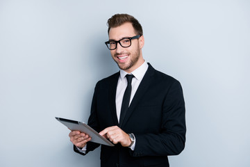 Portrait of professional stylish trendy smart clever dressed in formal suit employer is reading necessary information on the internet using digital table, isolated on gray background