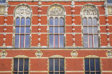 Obraz premium Architectural fragments of Historic building of Amsterdam central railway station (Amsterdam Centraal), Netherlands. Amsterdam Centraal's building first opened in 1889.