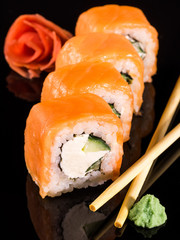 Japanese rolls on black background isolated with reflections