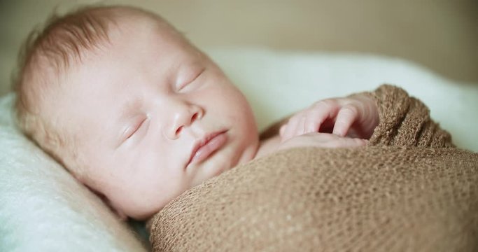 cute little baby boy sleeps sweetly on the bed in the room, close up
