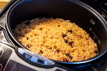 Close-up image of Pilaf with beef, carrots, onions, garlic, pepper and cumin in the modern multicooker. A traditional dish of Asian cuisine. Selective focus.
