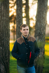 A young man in a park in a dark blue shirt. Spring