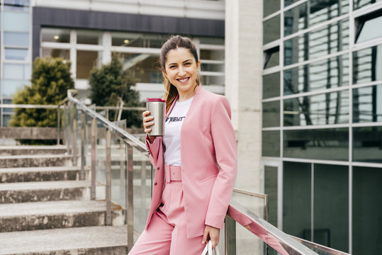 Confident trendy girl with coffee on steps