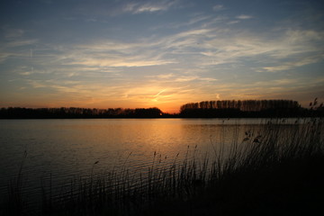 Naklejka premium colorful sunset over river Rotte in Zevenhuizen with reflection in the water in the Netherlands.