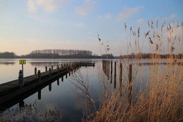 sunset over the river Rotte in Zevenhuizen near Rotterdam with reflection on the water and colored sky