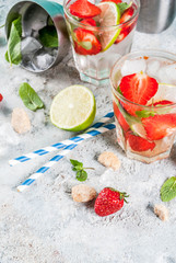 Summer refreshment drink, strawberry mojito cocktail on light concrete background, copy space