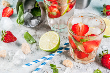 Summer refreshment drink, strawberry mojito cocktail on light concrete background, copy space