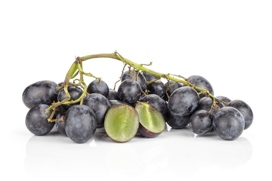 Black grape cluster (autumn royal variety) isolated on white background one purple berry cut in two halves.