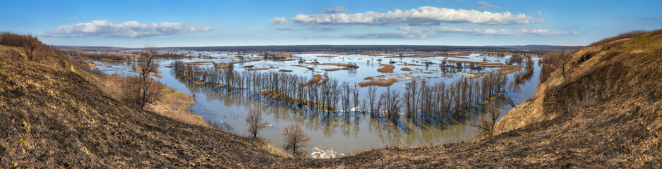 Spring landscape, panorama, banner - flood in river valley of the Siverskyi (Seversky) Donets, the winding river over the meadows between hills and forests, the northeast of Ukraine