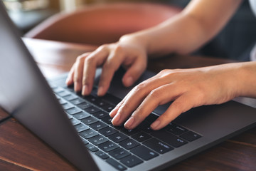 Closeup image of a business woman's hands working and typing on laptop keyboard