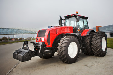 New Red modernized agricultural tractor with large wheels at the outdoor exhibition
