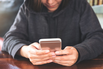Closeup image of a woman holding , using and looking at smart phone