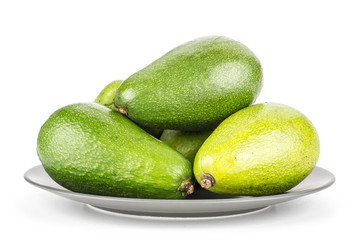 Green smooth avocado on a grey ceramic plate isolated on white background ripe shiny bacon variety.
