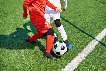 Child soccer players and ball on football field