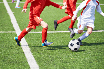 Naklejka premium Child soccer players and ball on football field