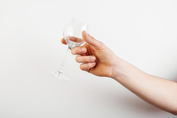 empty glass of wine in hand on a white background