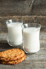 Fresh healthy milk and oatmeal cookies with cereals on wooden rustic background