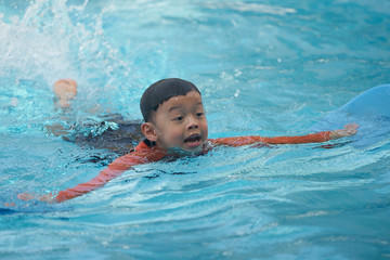 Fototapeta na wymiar Asian boy swimming in water pool