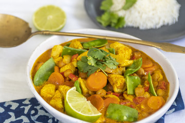 Chicken and Coconut Curry on a White Backdrop with a side of Rice and Lime