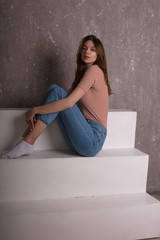 Test photo shoot for young lovely girl wearing jeans shorts and pink t shirt, sitting on a stairs