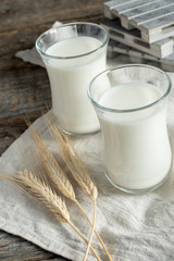 Fresh healthy milk in glass cups on wooden rustic background