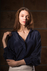 Fototapeta premium Test shooting for young stylish girl wearing blue silk blouse, posing in the shadows