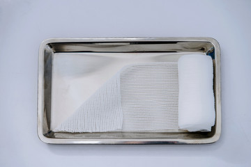 Roll gauze or thin bandage on medical tray on isolated white background for dressing or clean wound...