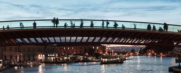 The Modern bridge in Venice at sunset with silhouettes of Tourists crossing a new bridge - low light - Italy