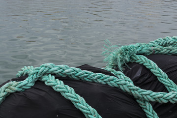 Primer plano de unas cuerdas sobre un montón de redes de pesca