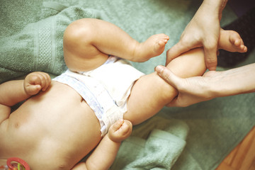 Mother massaging her little baby girl, shallow focus