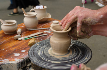 Fototapeta na wymiar clay jug on a potter's wheel during a master class at a fair