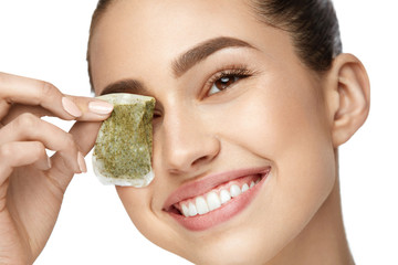 Eye Skin Care. Beautiful Woman With Green Tea Bag Under Eyes