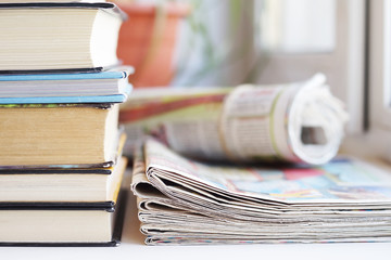 Pile of books and stack of newspapers. Daily papers with news and professional literature. Concept...
