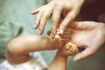 Mother massaging her little baby girl, shallow focus