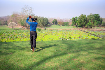 Man playing golf on a golf course.