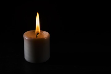 Obraz na płótnie Canvas a burning candle in the dark