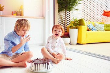 happy kids, brothers tasting birthday cake at home