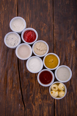 Obraz na płótnie Canvas Ketchup, mustard, butter, sauce with greens, sour cream sauce, sauce with paprika, pomegranate sauce