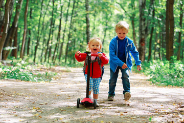 little girl riding scooter and boy running, kids sport