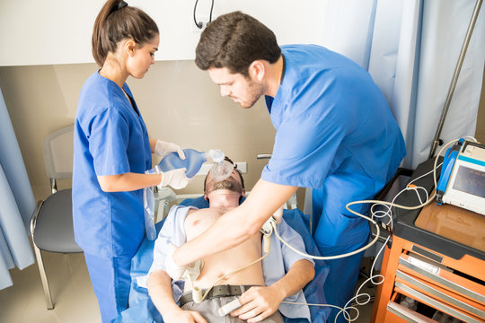 Doctors performing defibrillation on a patient