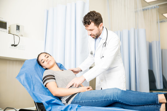 Doctor checking woman with stomach ache