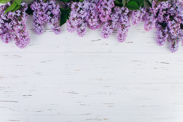 The beautiful violet lilac on a white wooden background. Flat lay and copy space composition.