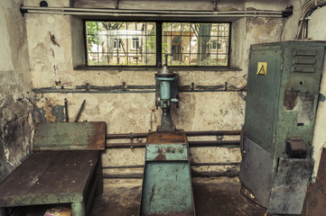 Electro drill with a view/boring machine and generator in a small below ground room with an upper window into the street.