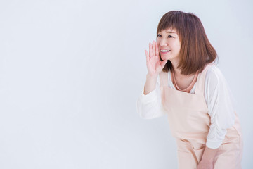 なにかを伝えるエプロン姿の女性
