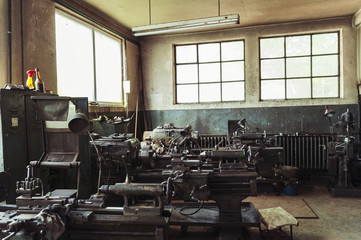 Mechanical workshop/Old metal spare parts workshop with vintage turning machines and tool kits.