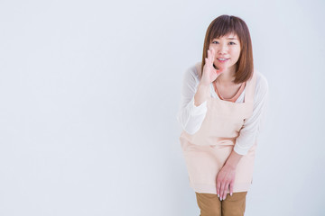 なにかを伝えるエプロン姿の女性
