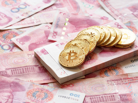 Close up image of piles of golden Bitcoin on piles of 100 yuan or renminbi banknotes, Financial concept, Chinese Currencies.