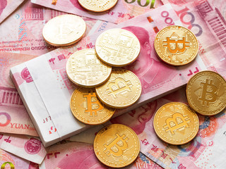 Close up image of piles of golden Bitcoin on piles of 100 yuan or renminbi banknotes, Financial concept, Chinese Currencies.