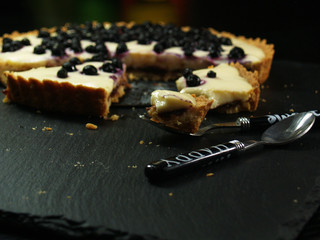 Ciasto z kremem i jagodami, krucha tarta na stole, pokrojona, owoce i wanilia
