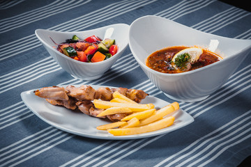 Set of three dishes. Business lunch of three dishes. Three dishes on white plates on a table with a...